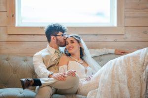 Couple sharing tender moments in a rustic wooden cabin setting.
