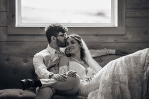 Intimate black and white moment captured on couch in rustic setting.