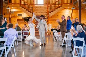 Newlyweds make grand entrance dancing into rustic barn reception venue.