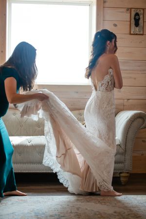 A series of artistic bridal portraits showing the flow of a white lace wedding dress in a rustic wooden room.