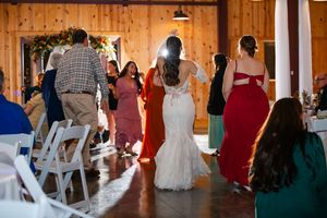 Wedding reception dance party in a rustic wooden barn venue with guests celebrating.