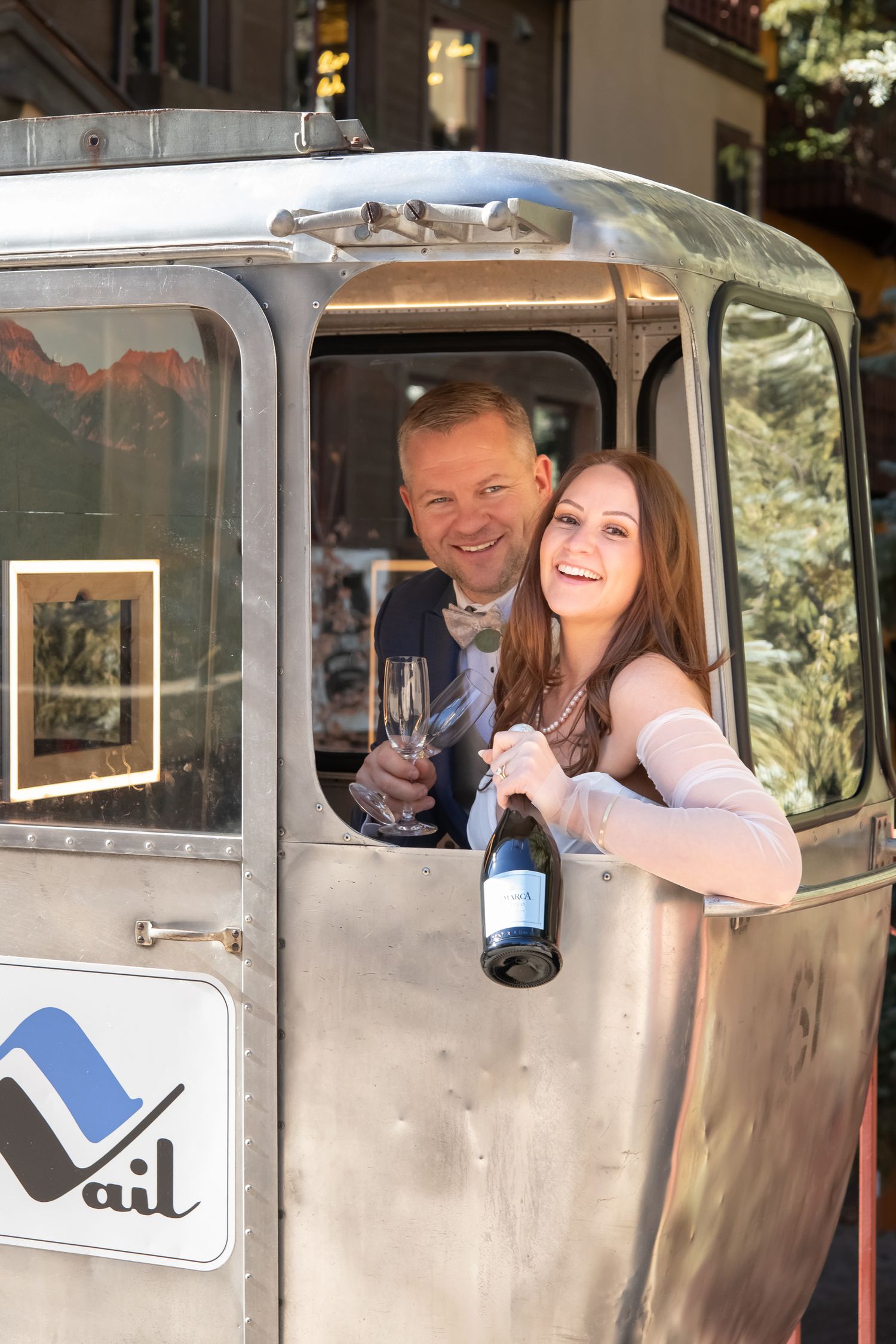 Vail Village cute wedding photos with a vintage gondola and bottle of champagne