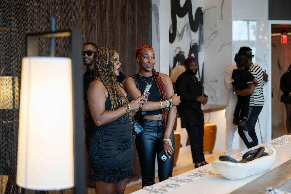 Guests mingling at an indoor event space with modern white decor.