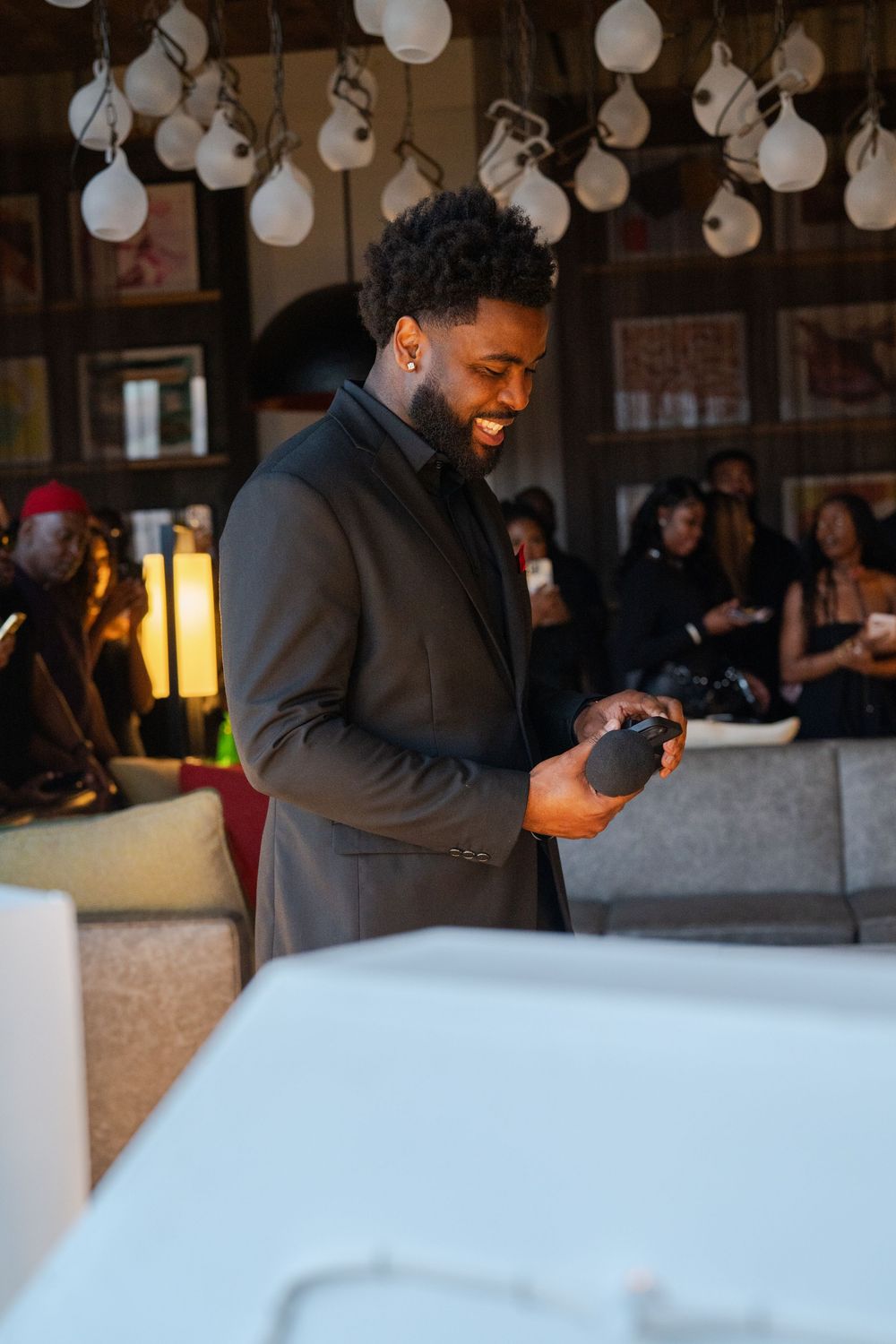 Person in dark attire interacting with white decor at an elegant indoor event venue.