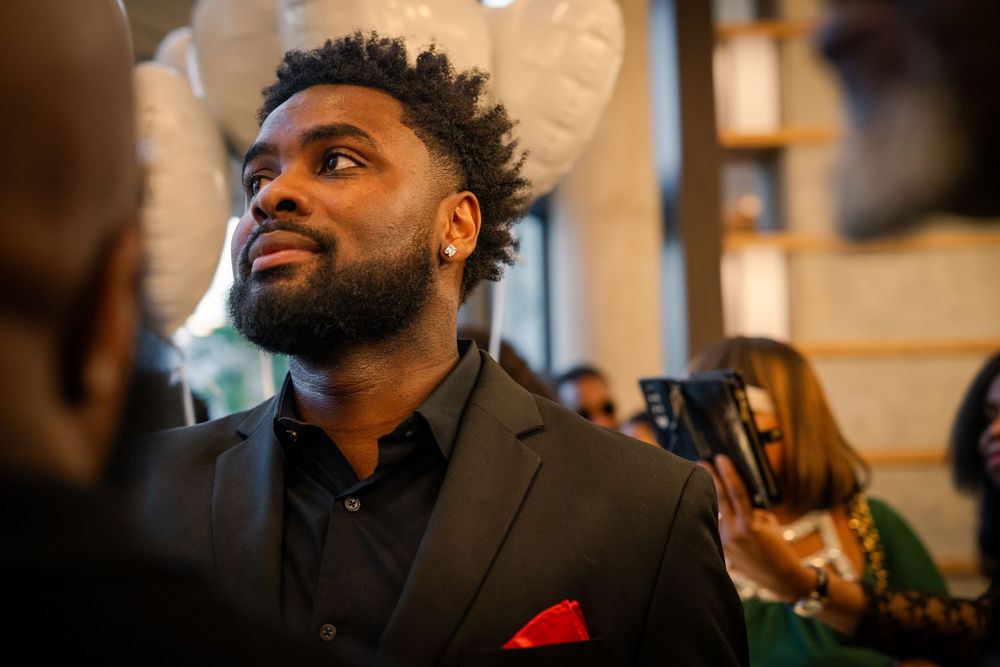 Formal event attendee in dark suit jacket with red pocket square.