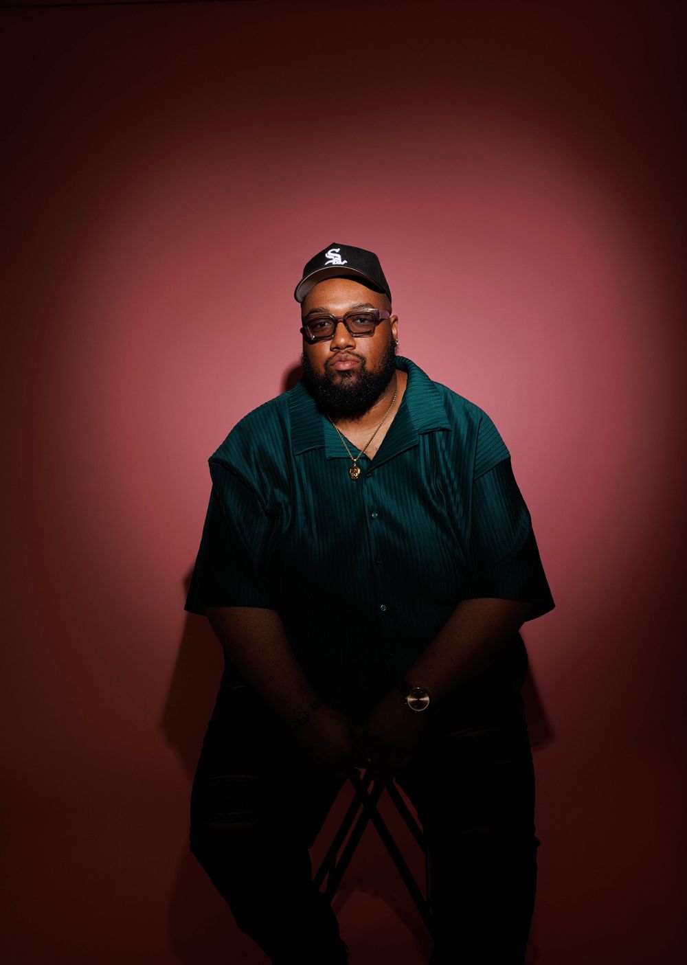 Professional studio portraits with dramatic lighting against a dark red background.