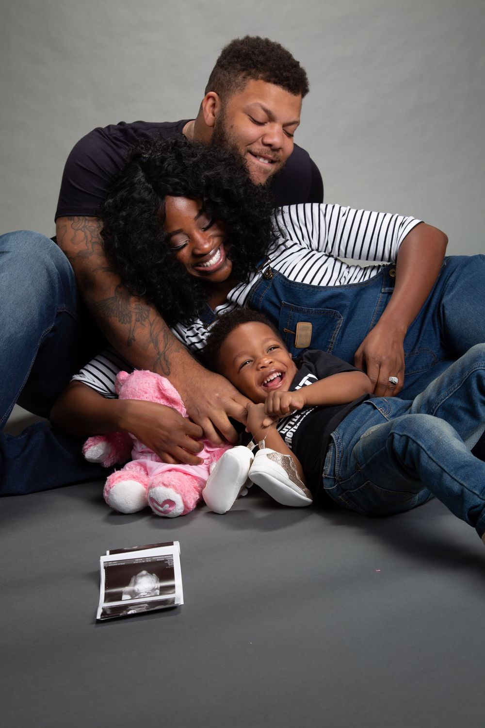 A heartwarming series showing intimate family moments on a gray studio floor.