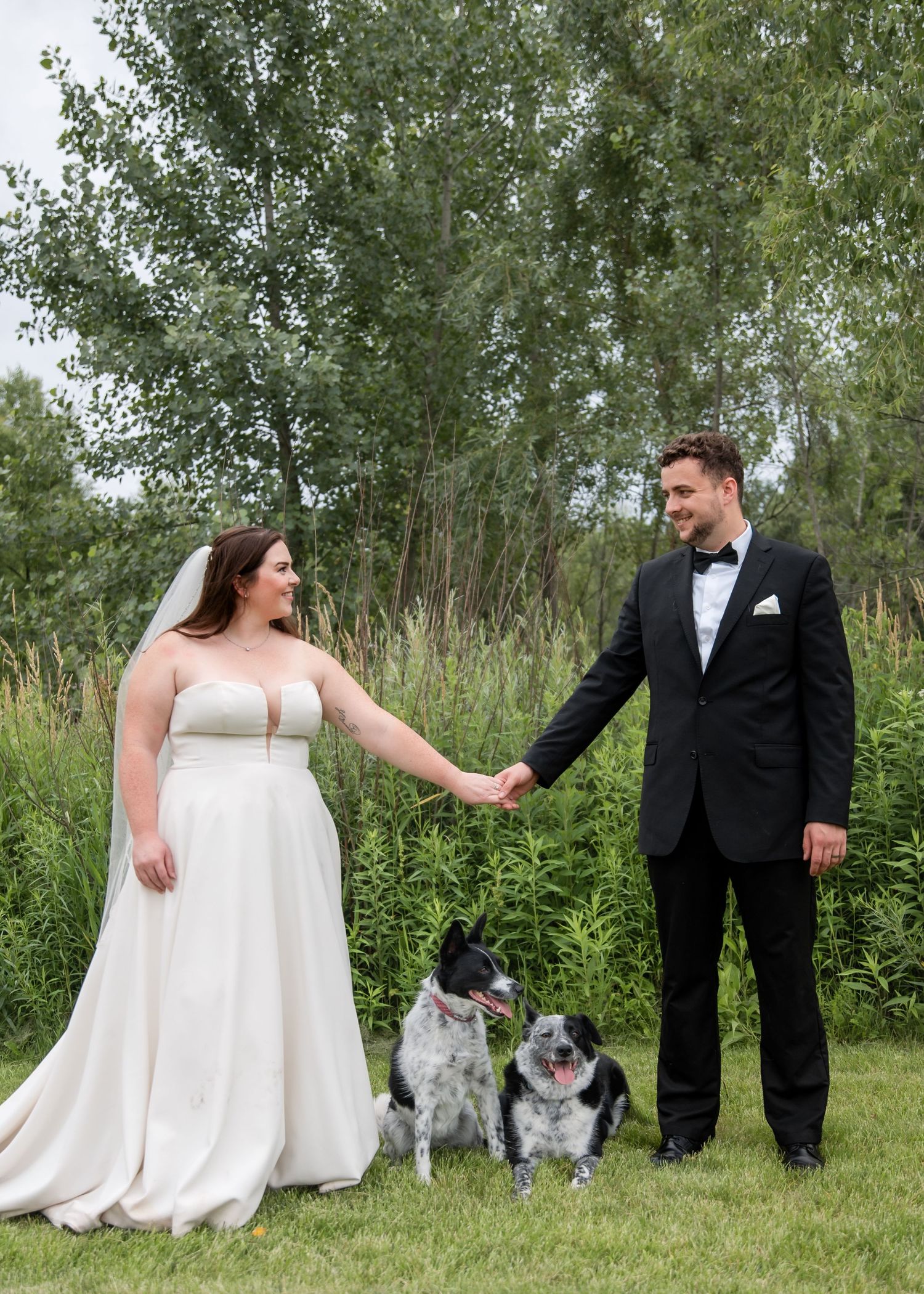 A couple and their dog pose together in a series of outdoor wedding photos among trees and greenery.