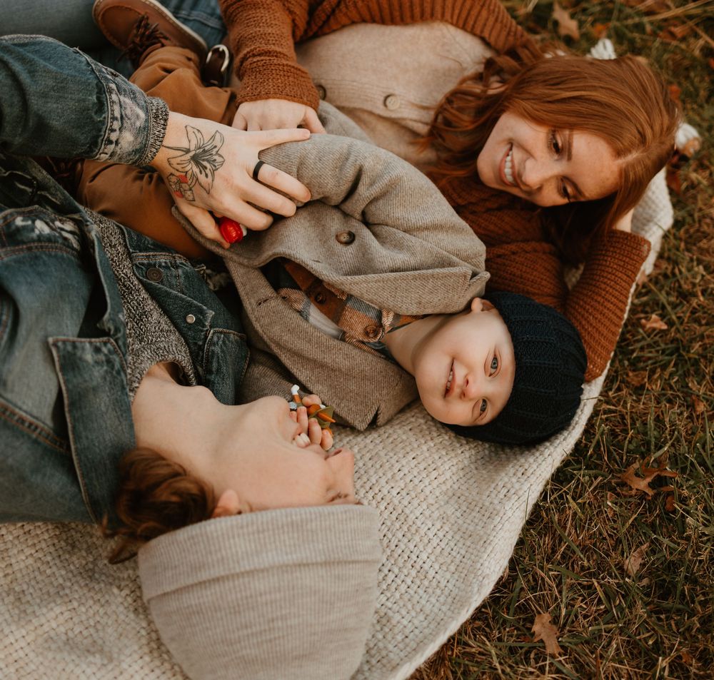 Intimate lifestyle photography session on a knit blanket with warm autumn colors and natural lighting.
