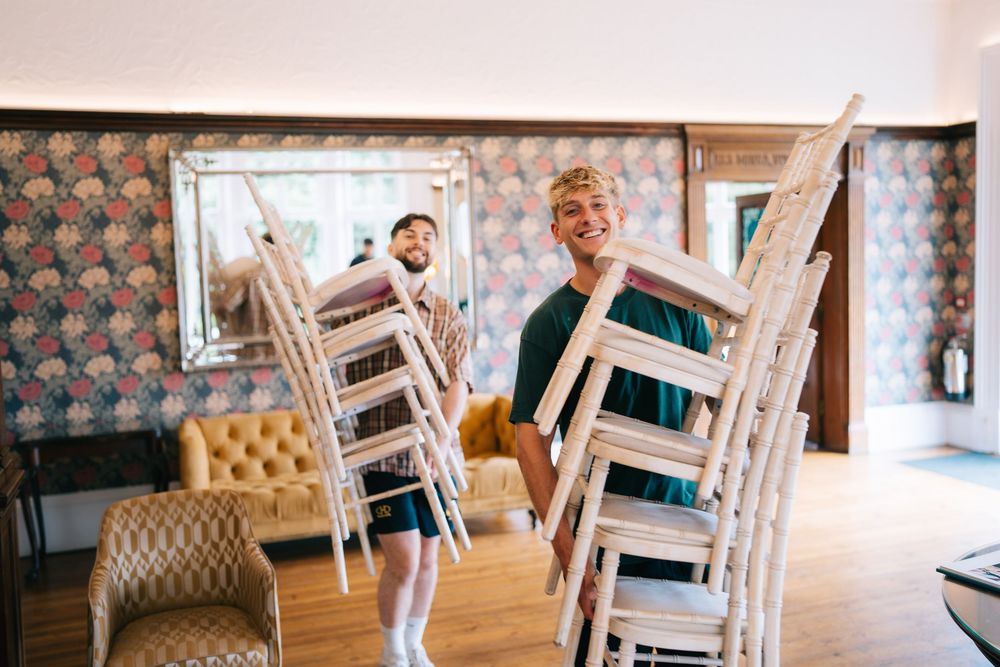 Vintage-style chairs arranged in an elegant indoor setting with patterned wallpaper  at Pendrell Hall wedding venue