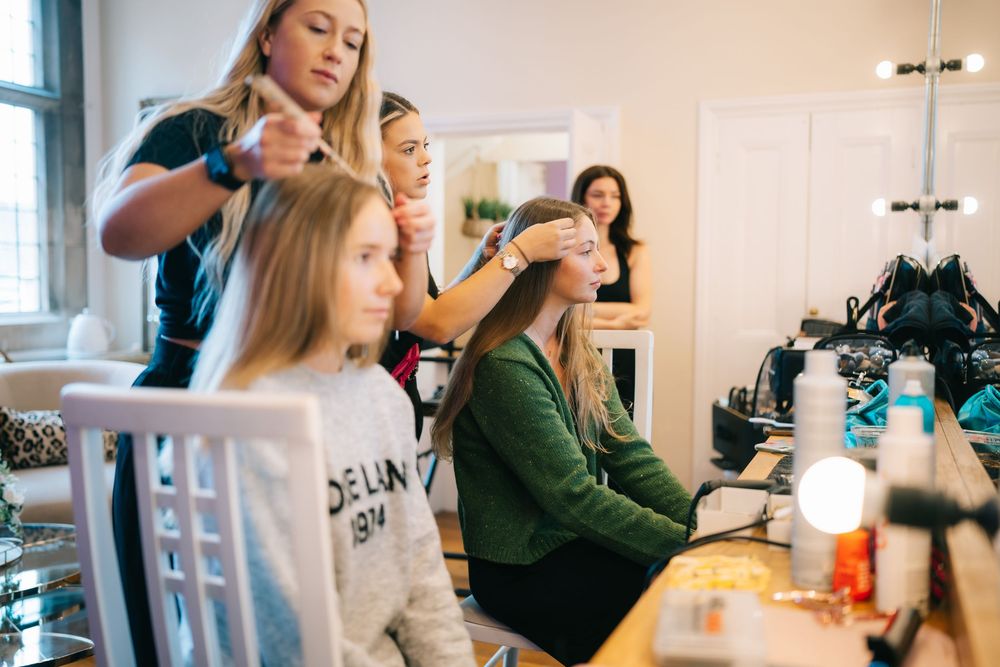 Group getting ready in a bright room with makeup and styling preparations for a special event  at Pendrell Hall wedding venue