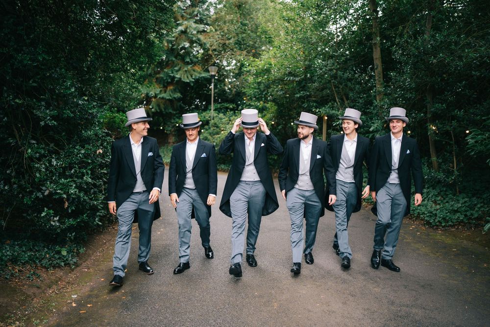 Groomsmen walking in synchronized formation on garden path at Pendrell Hall wedding venue