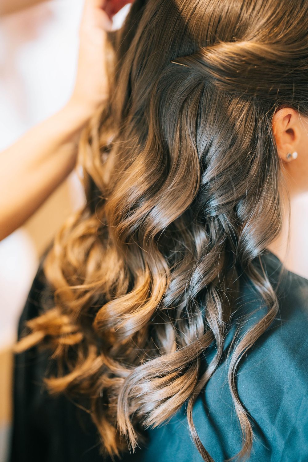 Close-up of elegantly styled wavy brown hair with soft curls for a special occasion at Pendrell Hall wedding venue
