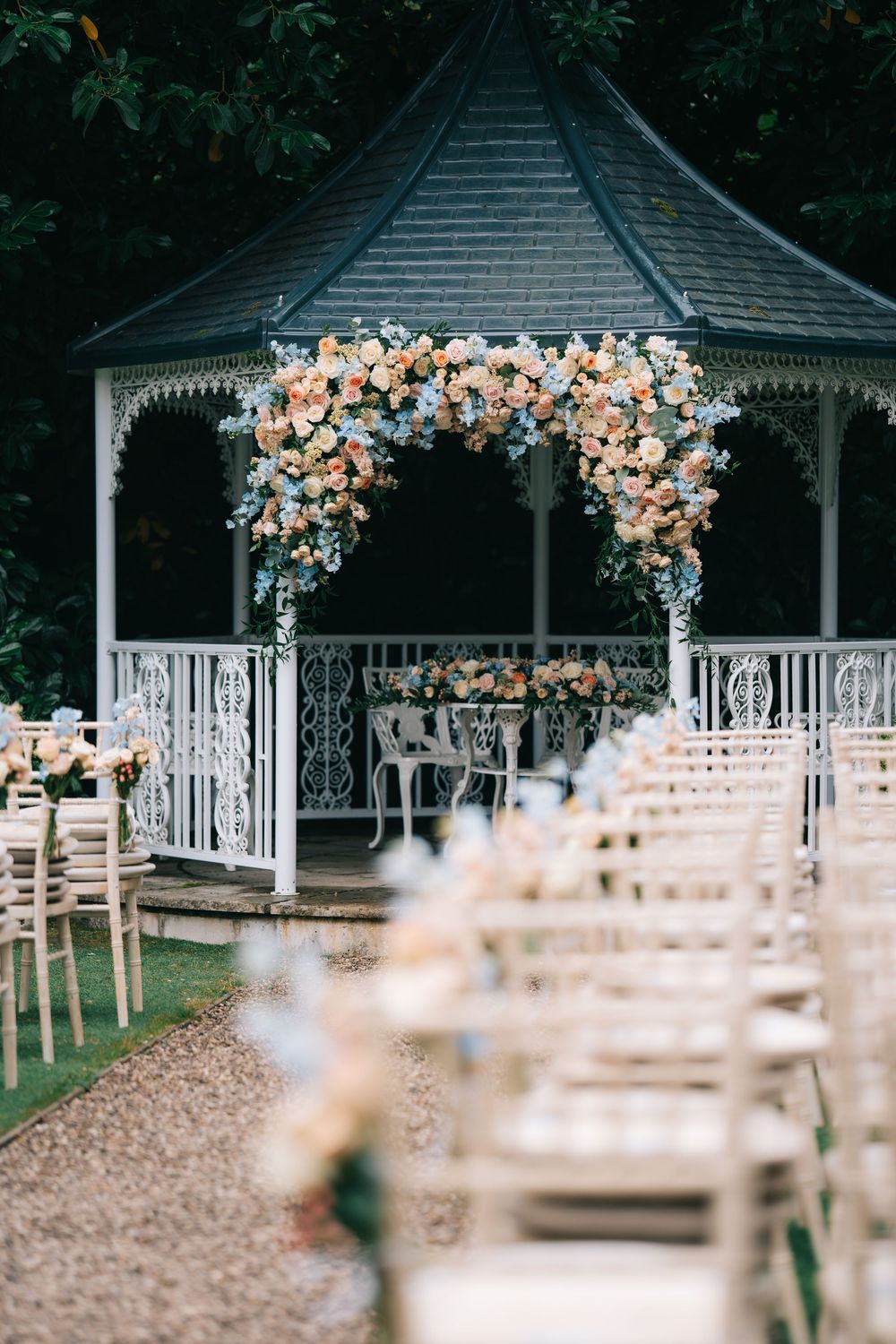 White gazebo decorated with lush peach and cream floral arrangements for outdoor wedding ceremony  at Pendrell Hall wedding venue