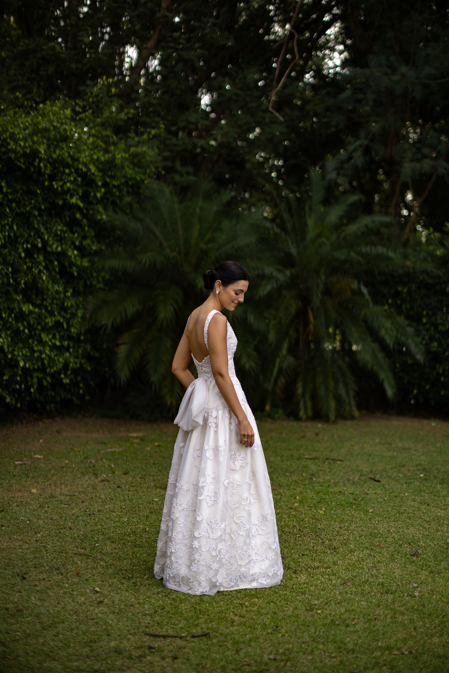 A person in a white lace dress twirls in a garden setting, creating a graceful spinning motion across multiple frames.