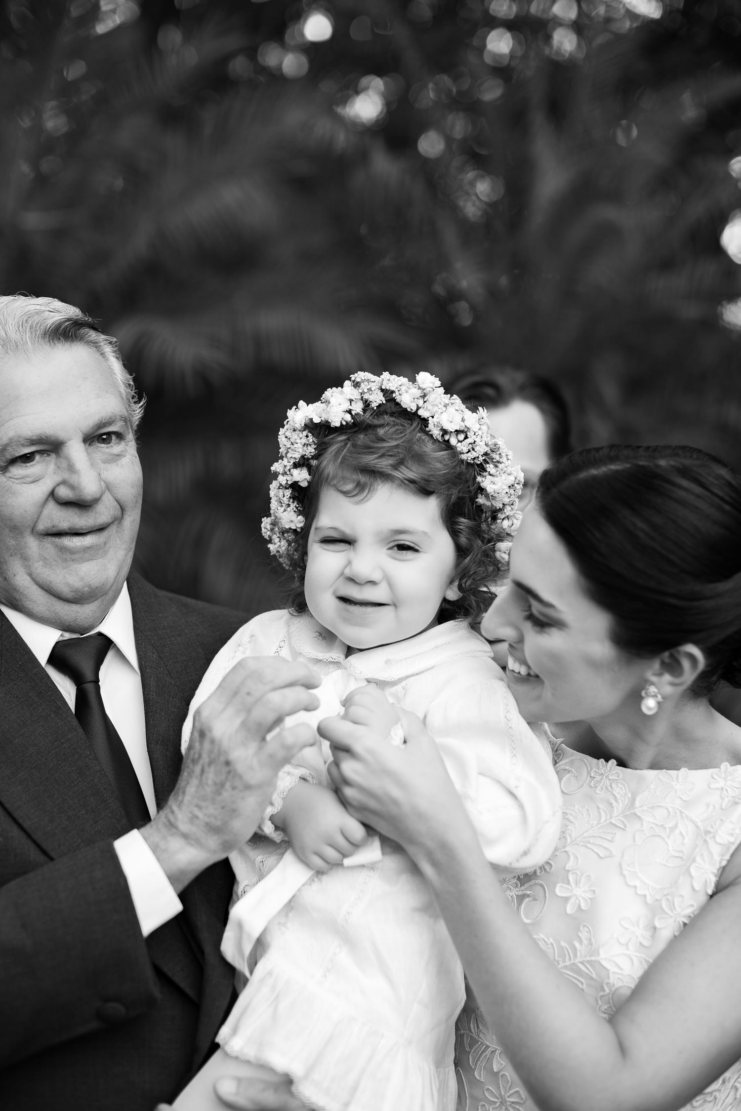 A black and white photo series showing tender moments between a family during a wedding celebration.
