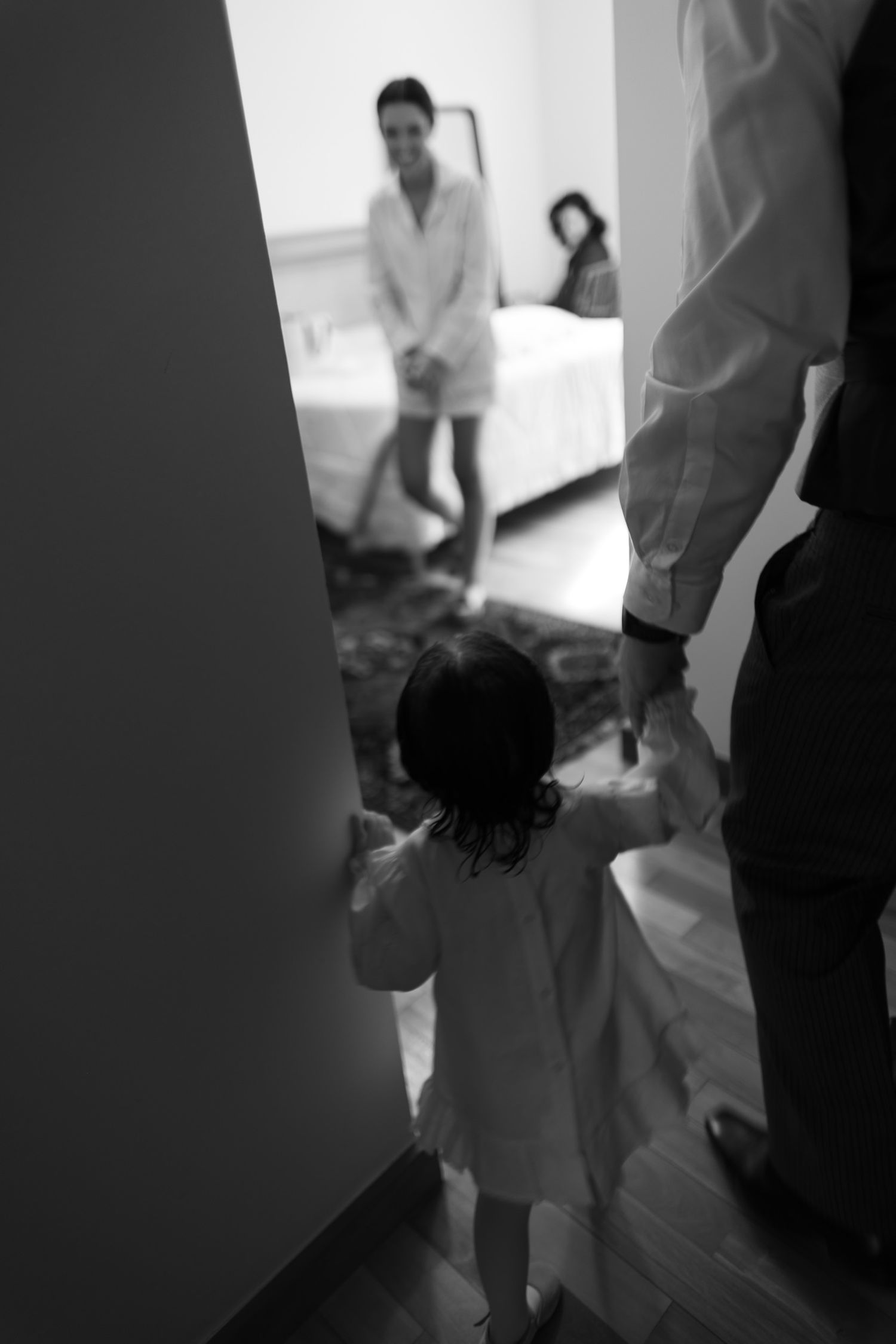 Medical professionals in white coats gather around a patient bed during an examination in a clinical setting.