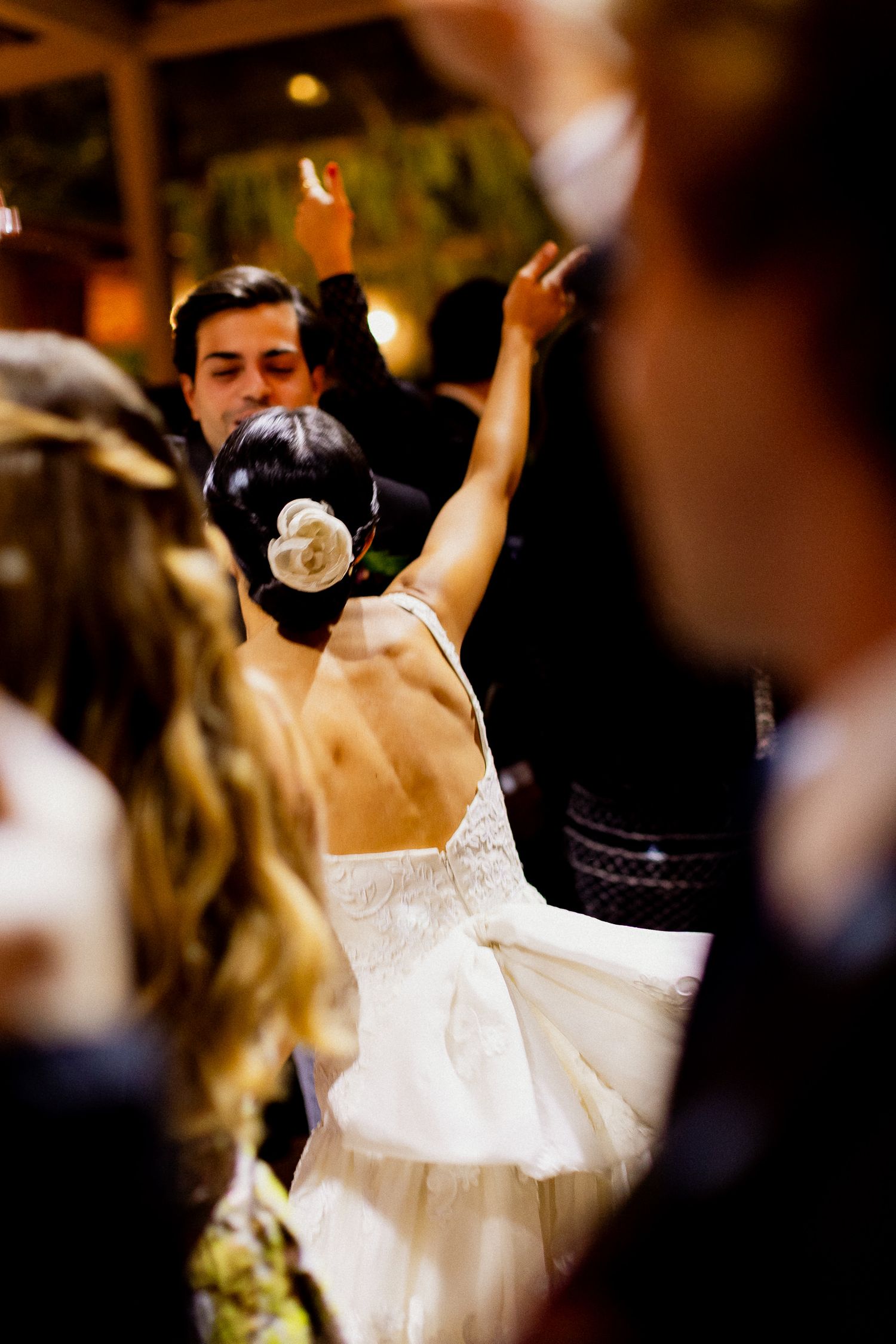 A bride in a white wedding dress spins and dances gracefully during a wedding reception celebration.