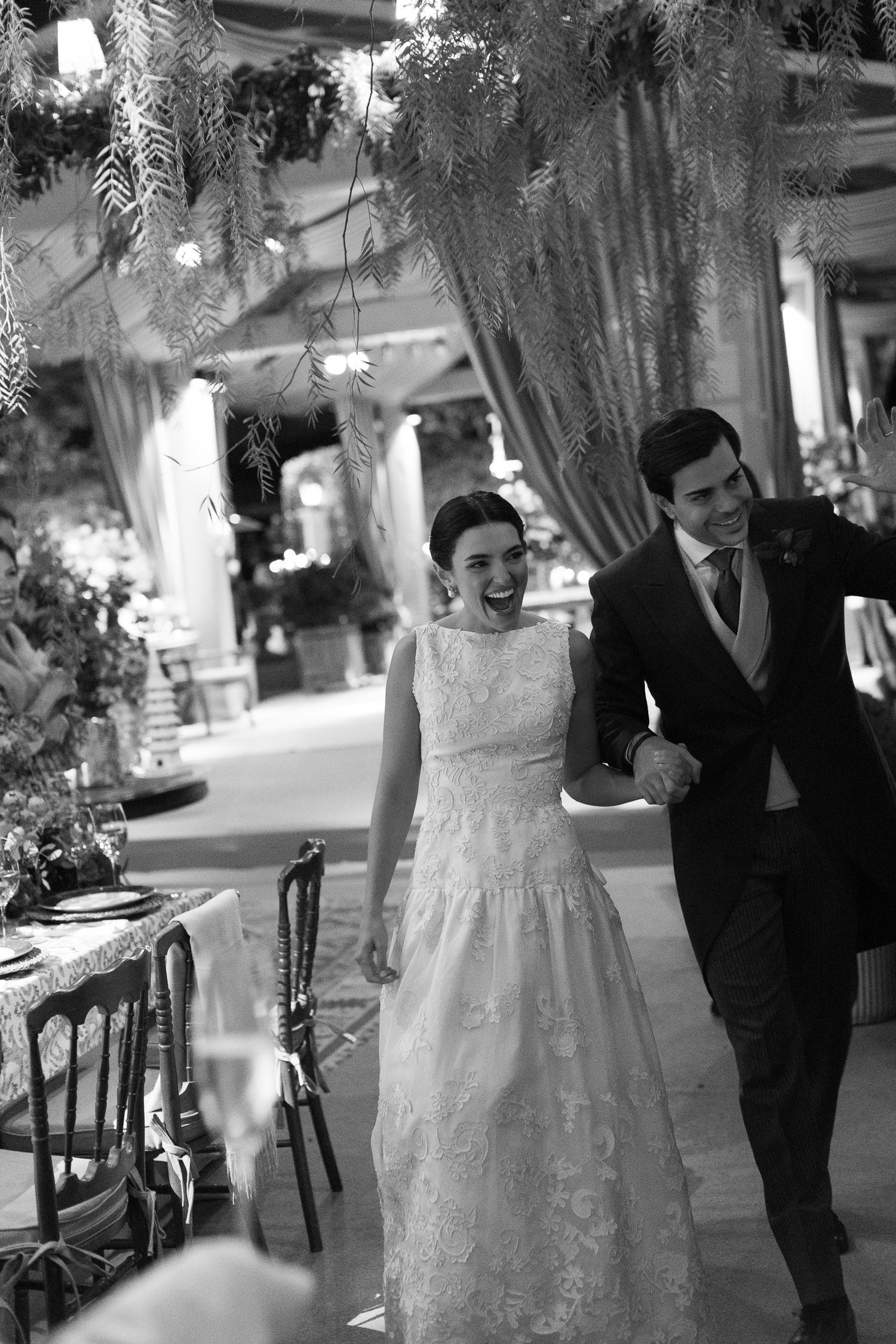 A sequence of black and white photos captures a couple's romantic walk through an ornate venue.