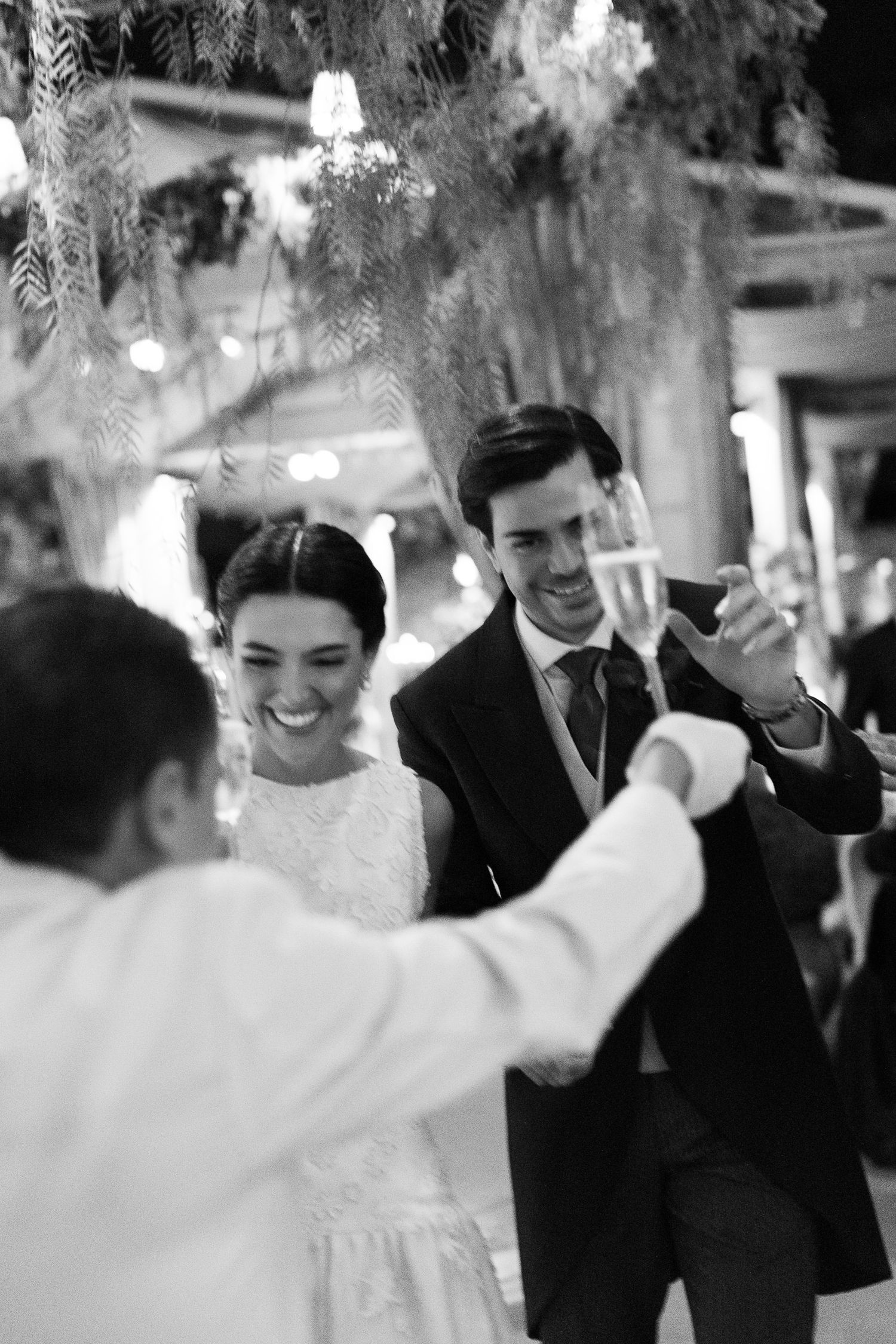 Black and white candid shots show joyful moments between a couple during their wedding celebration.