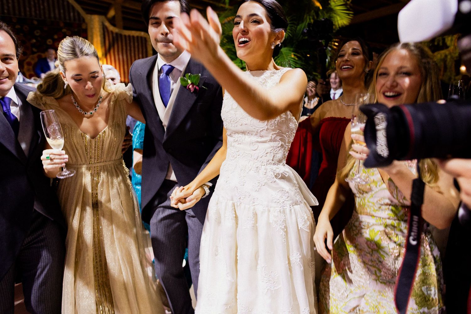Wedding guests dance and celebrate on the dance floor during an energetic reception party.