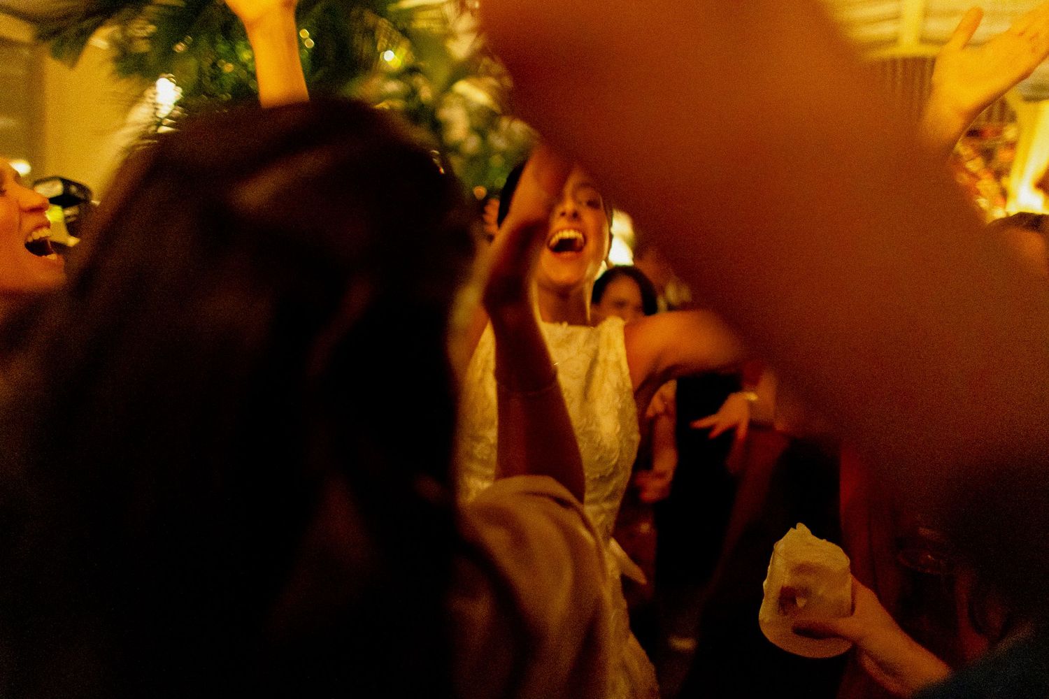 A dimly lit nightclub scene with people dancing and moving to music in an amber-colored atmosphere.