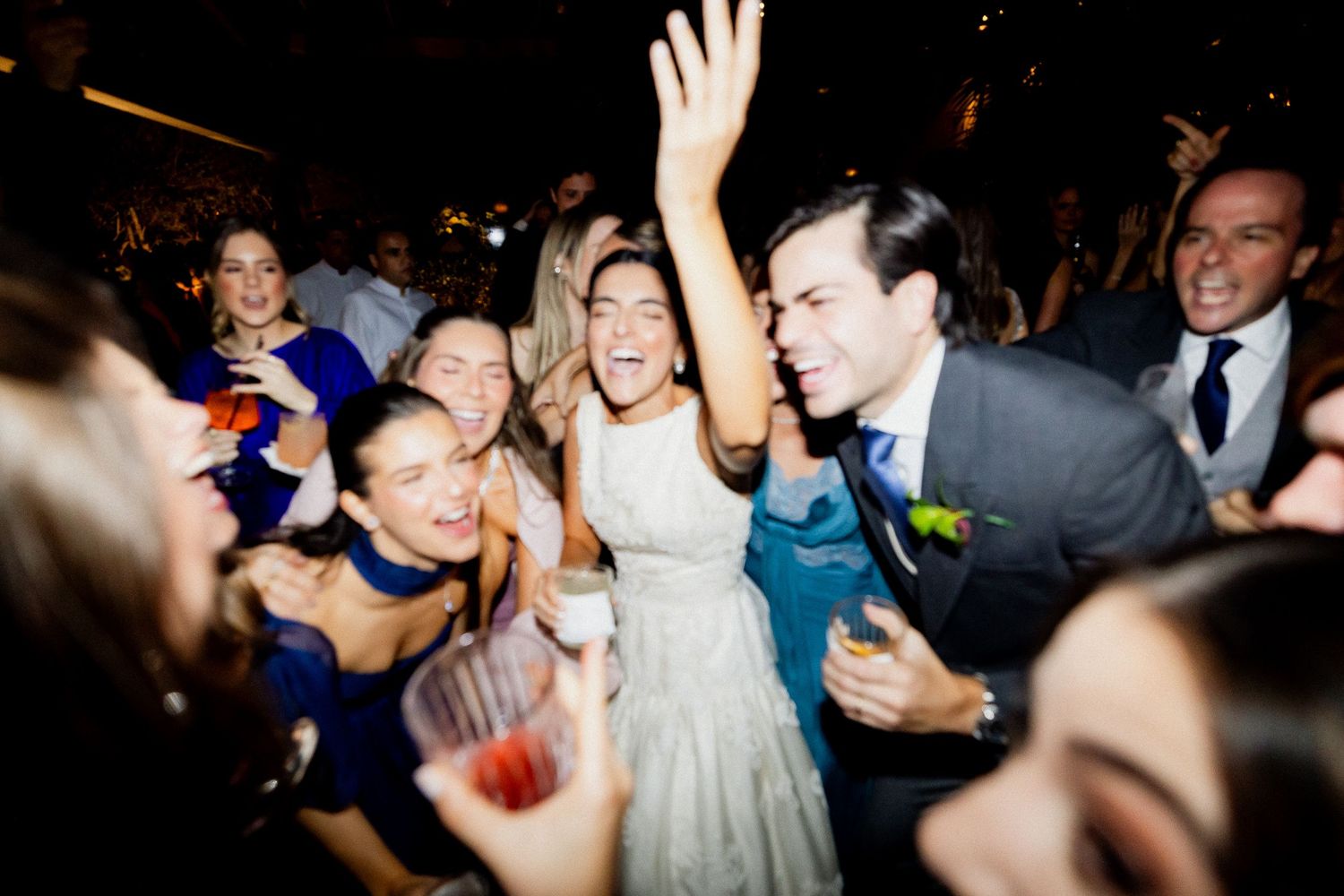 A lively dance floor filled with wedding guests celebrating and dancing at a reception party.