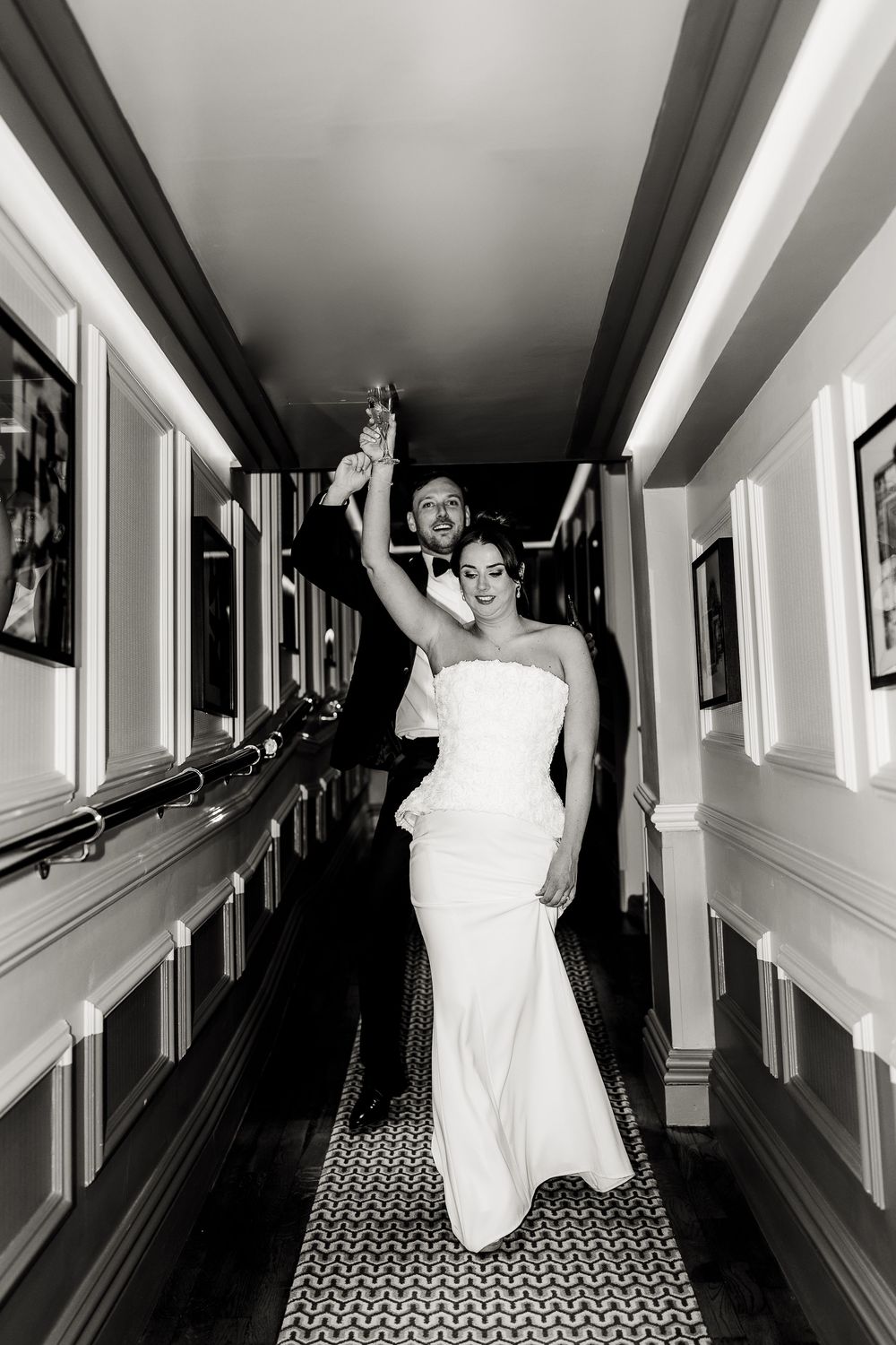 A series of black and white photos showing someone in a white dress playfully posing in a hotel hallway.