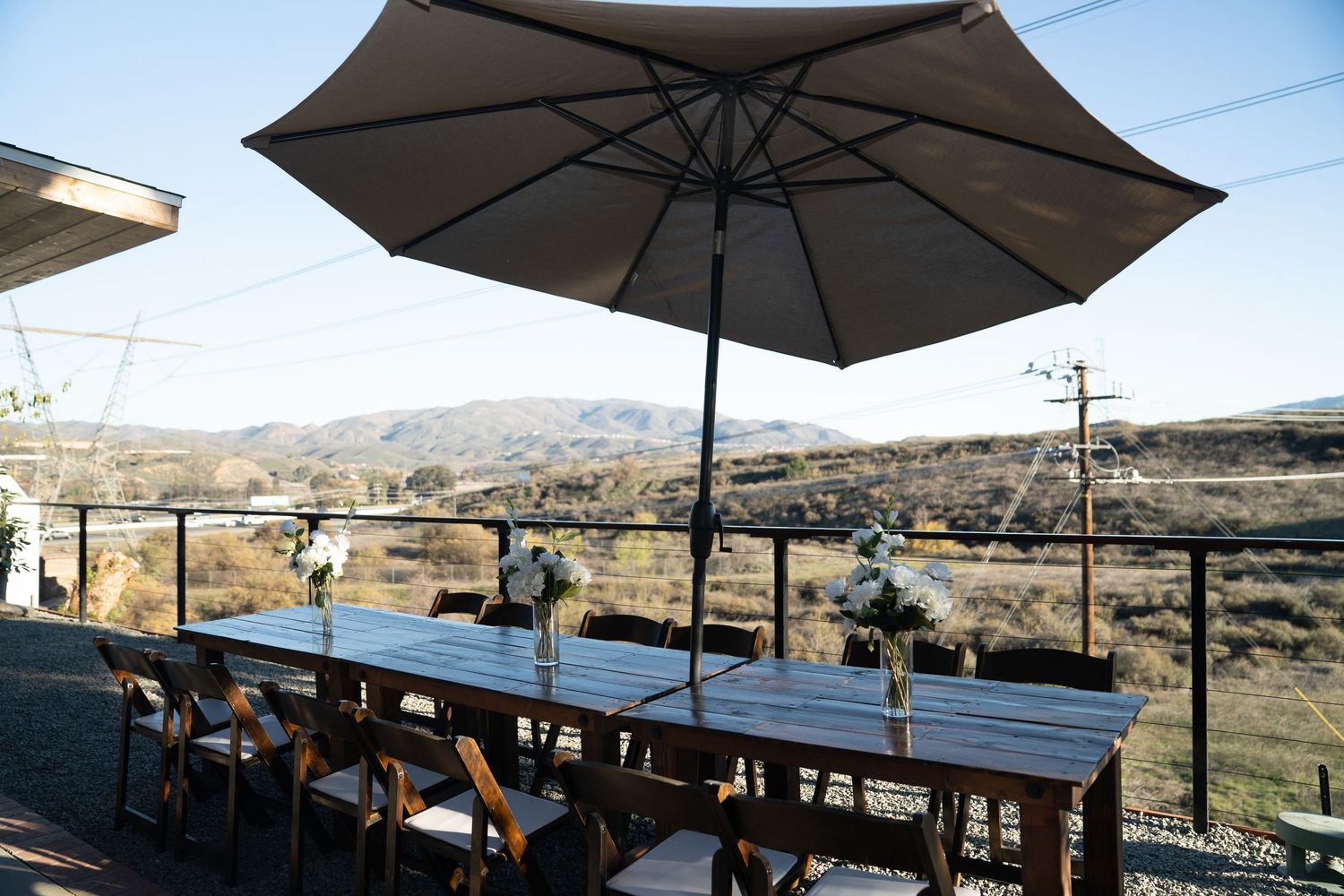 Outdoor dining setup with large umbrella and mountain views.