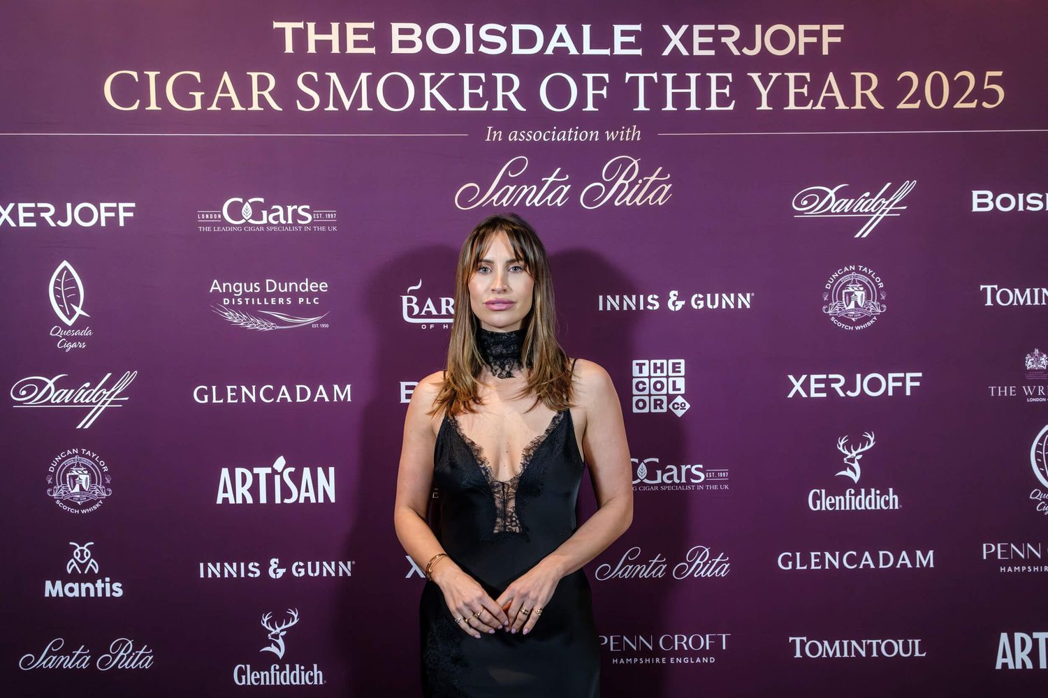 Purple and gold branded backdrop wall with luxury cigar and spirits company logos displayed at an awards event.