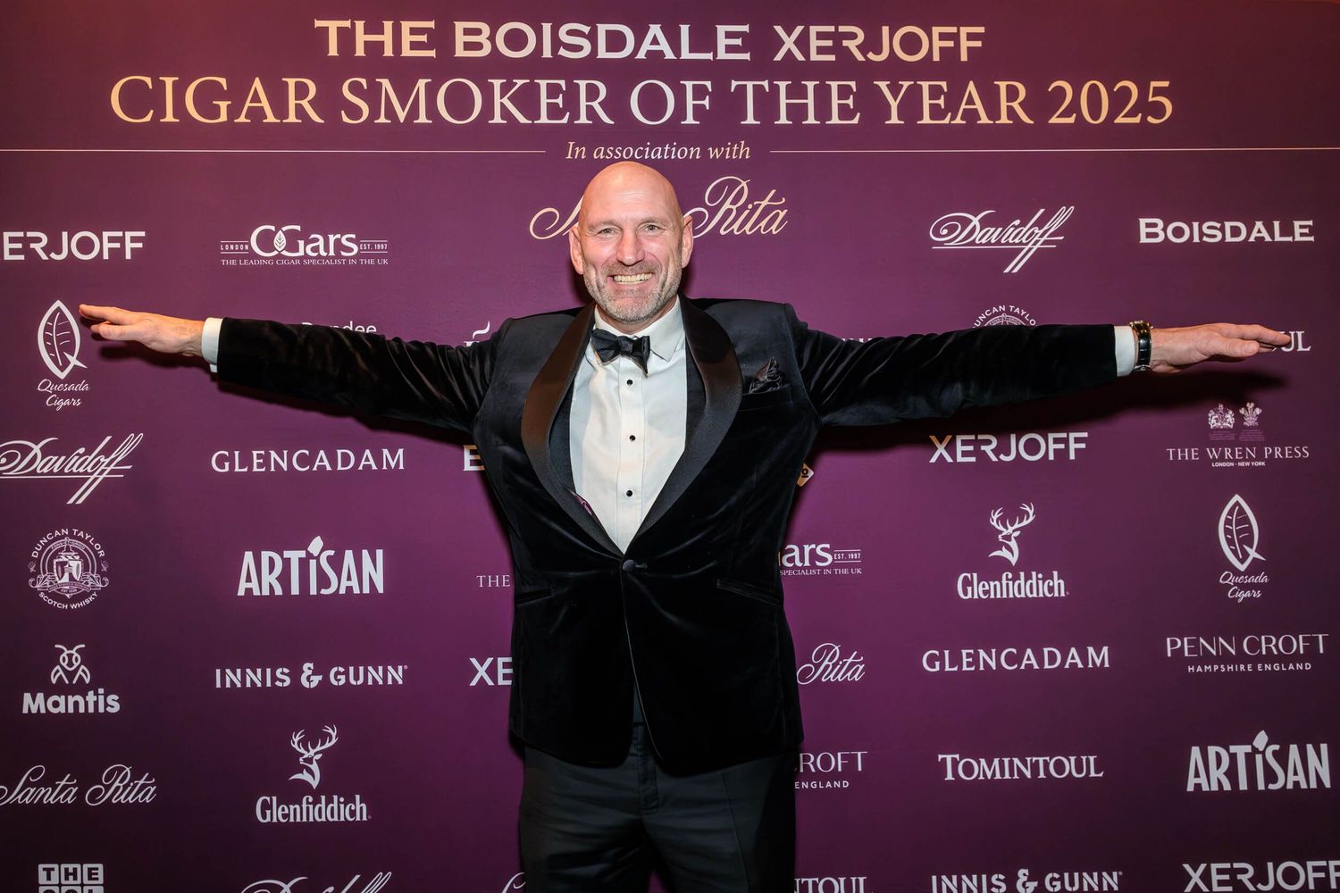 A purple and black backdrop with luxury cigar brand logos including Boisdale and XE3OFF repeated across the banner.