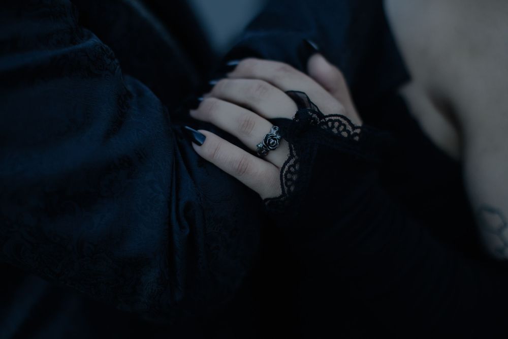Artistic black and white detail of hands against dark fabric.
