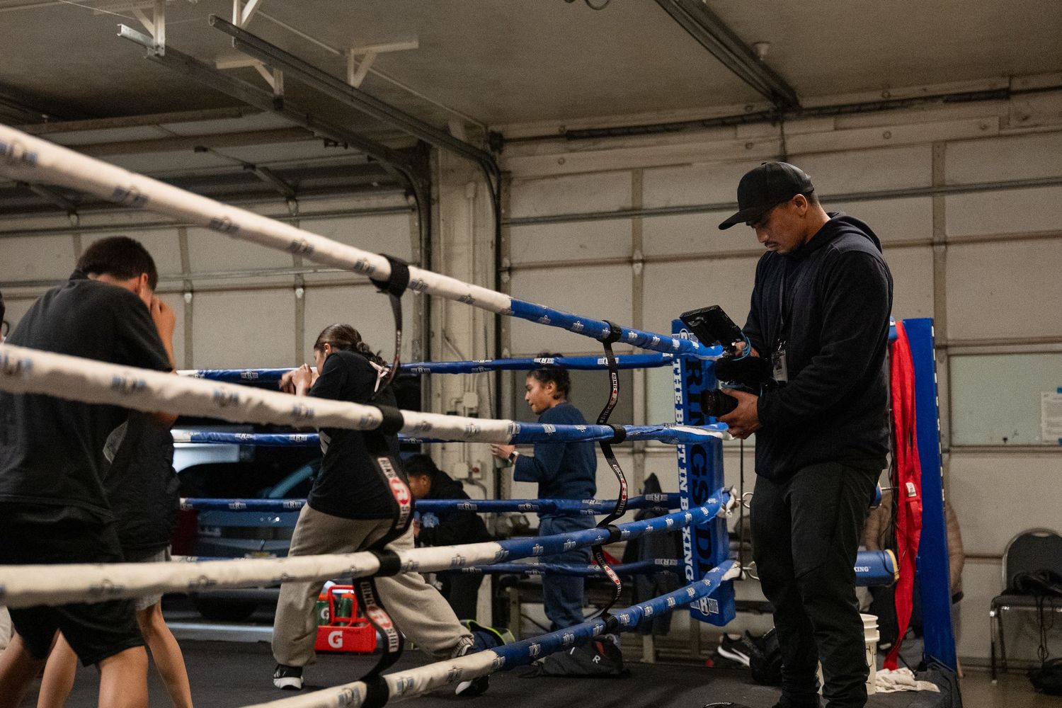 Boxing ring ropes and equipment inside a training gym facility.