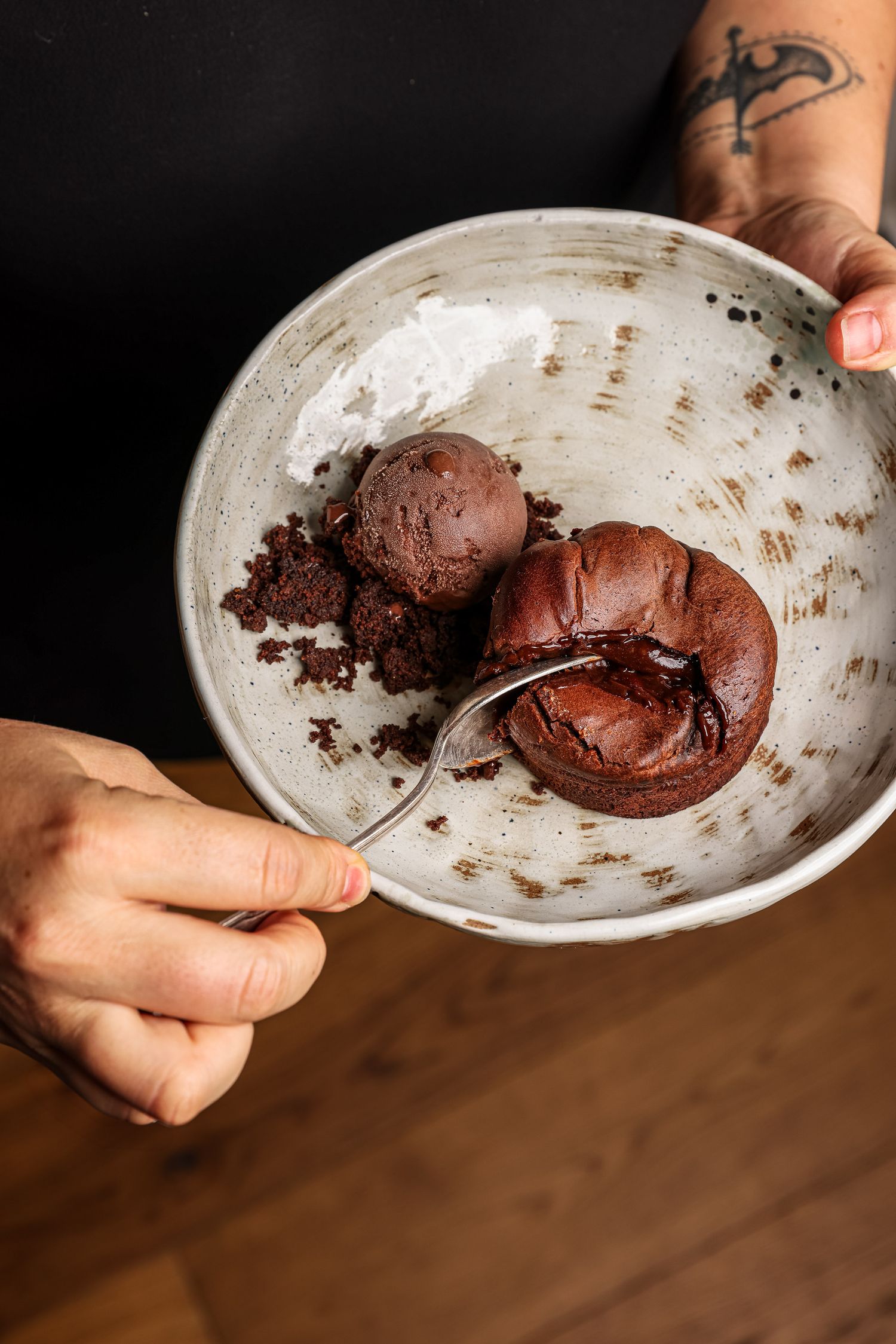 A sequence of photos showing chocolate cookie dough being scooped and rolled into balls on a white plate.