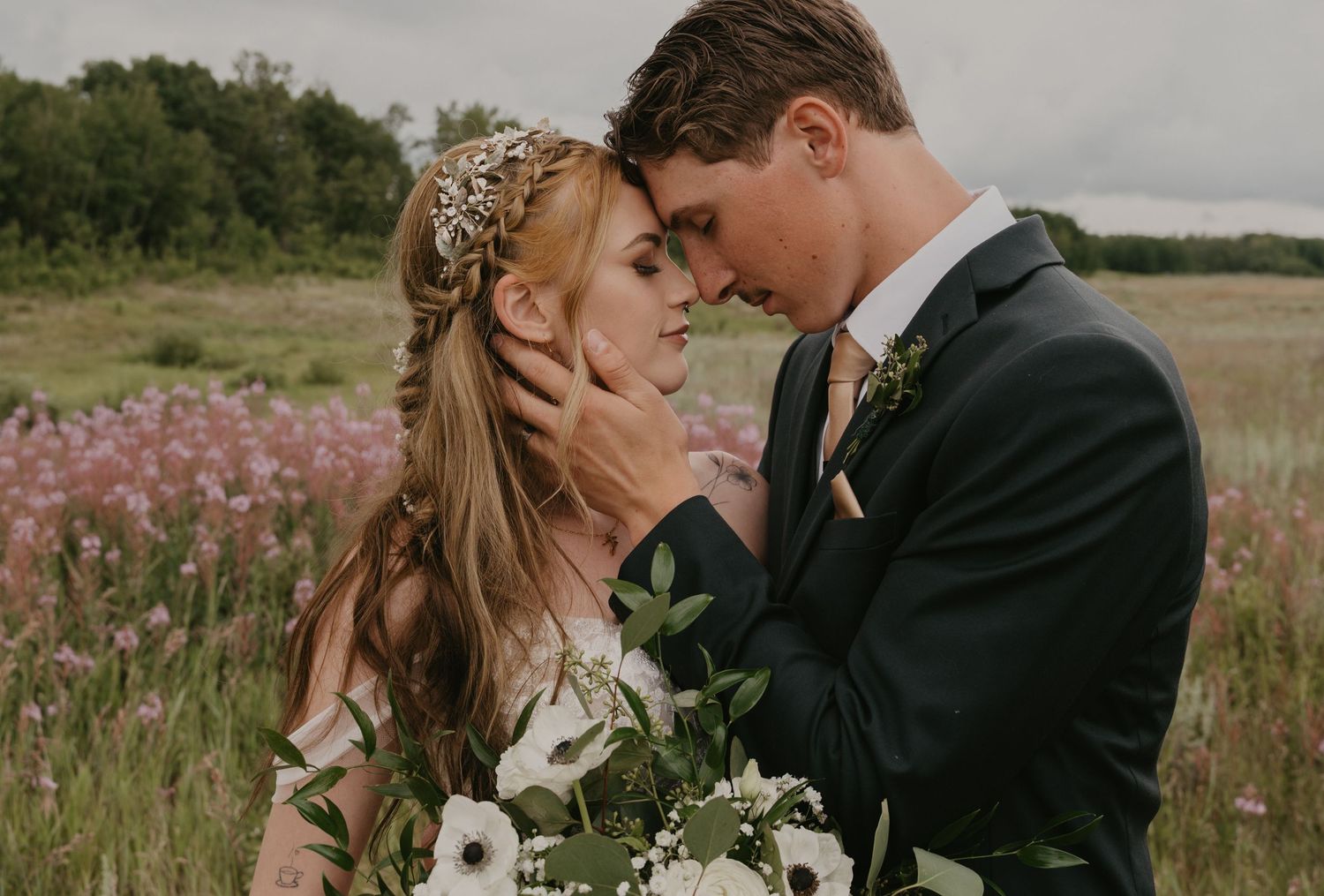 A couple shares an intimate moment together in a field of wildflowers during their wedding photoshoot.