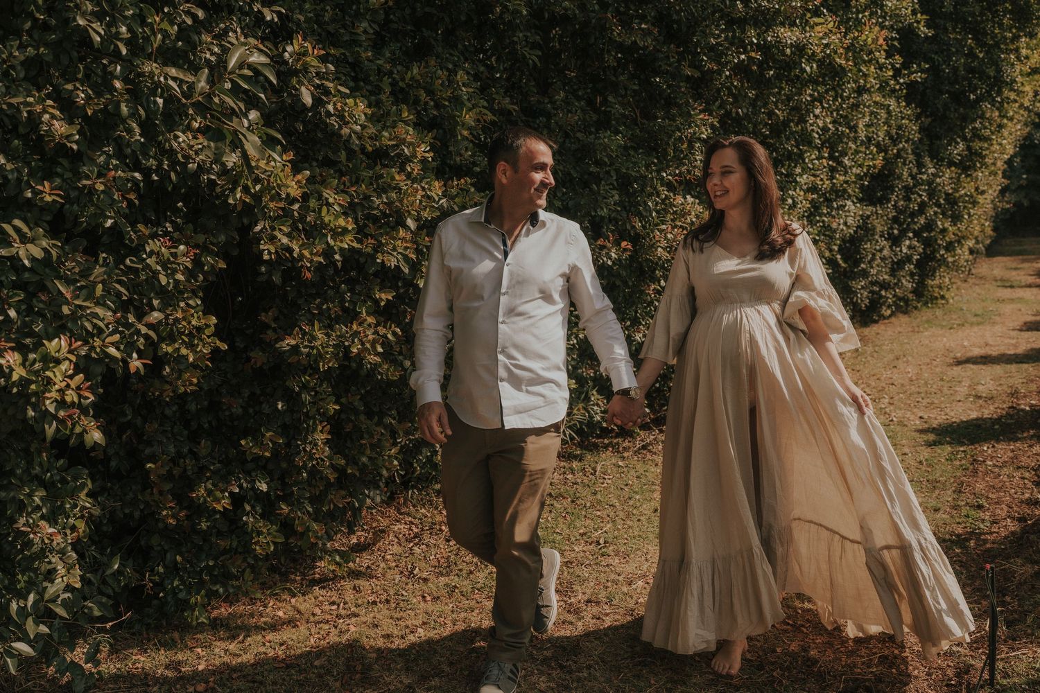 A loving couple shares an intimate moment while standing together in a natural outdoor setting.