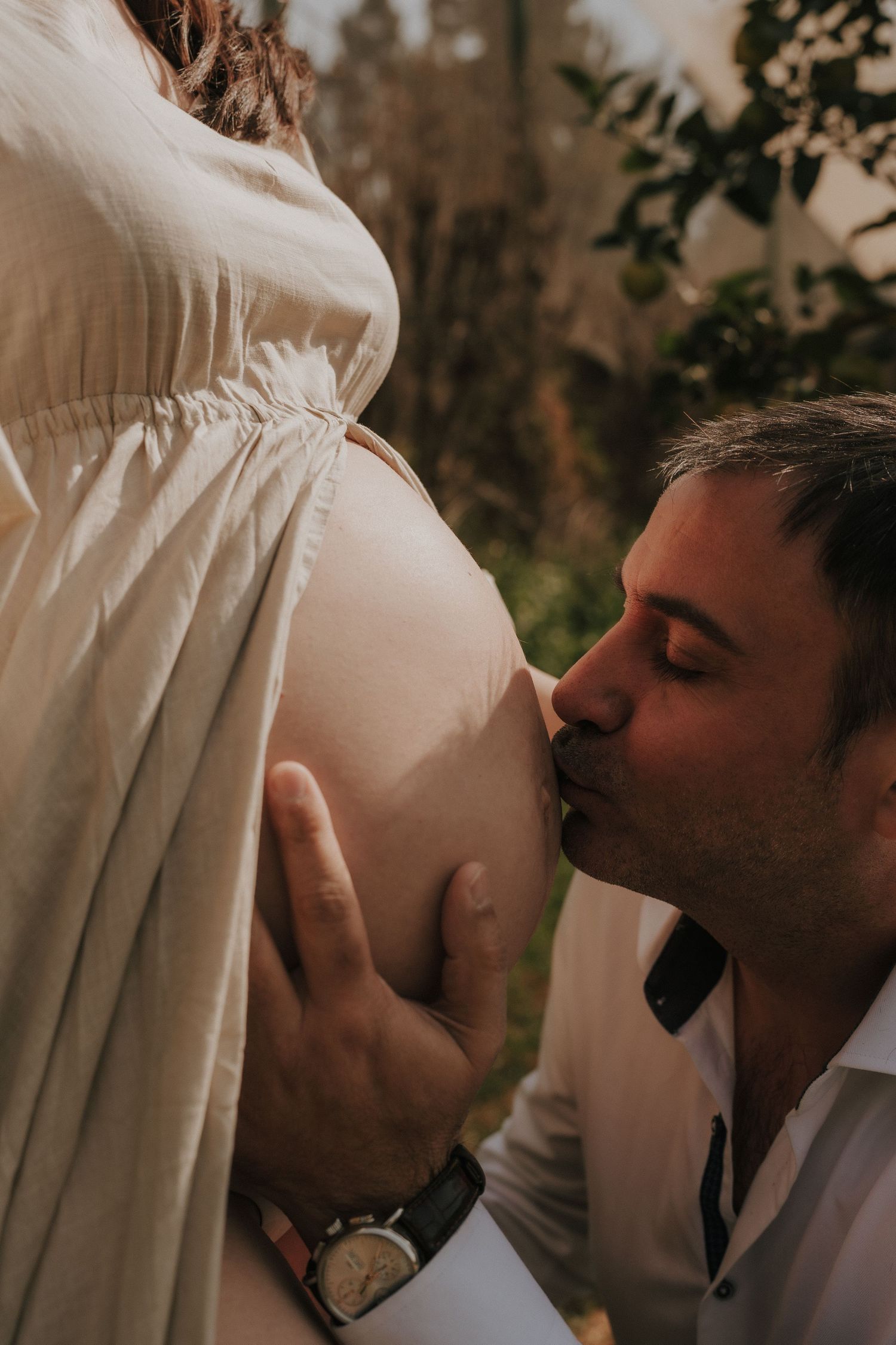 Intimate moment captured between couple during maternity photoshoot.