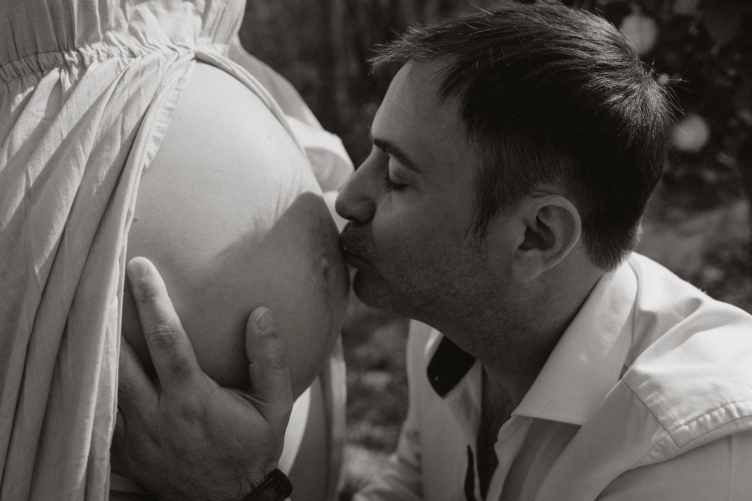 Black and white intimate portrait showing tender moment between partners.