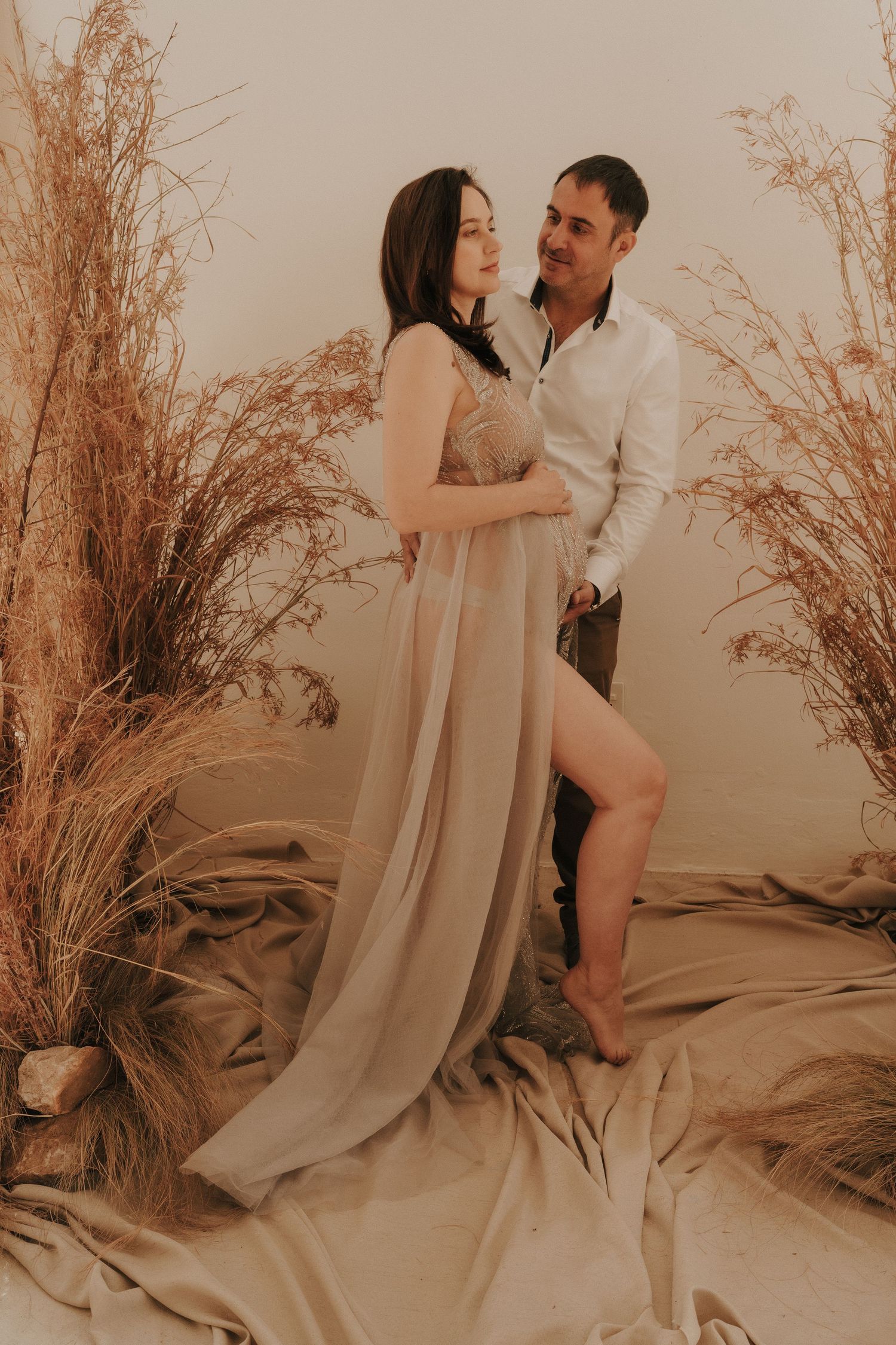 Intimate couple's portrait session with warm sepia tones and natural decor.