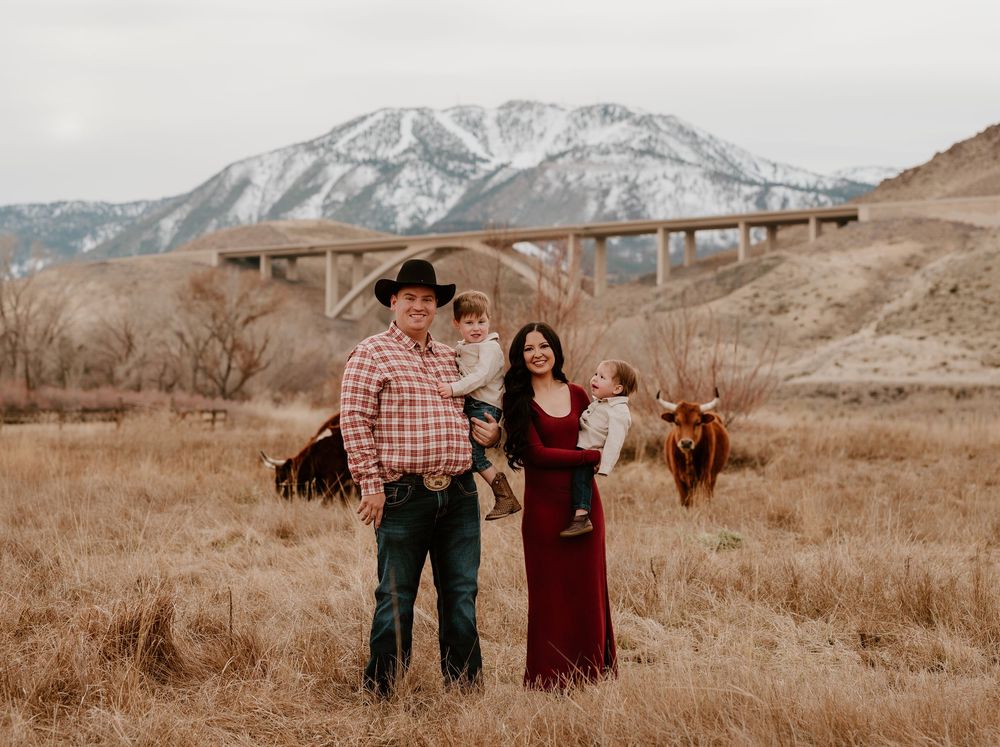 A couple stands together in a scenic mountain landscape during a fall engagement photo session.