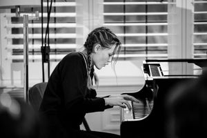A black and white photo of someone practicing piano in a studio setting.