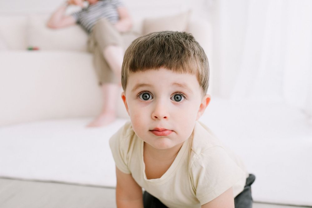 Young child playing in bright white minimalist room setting.
