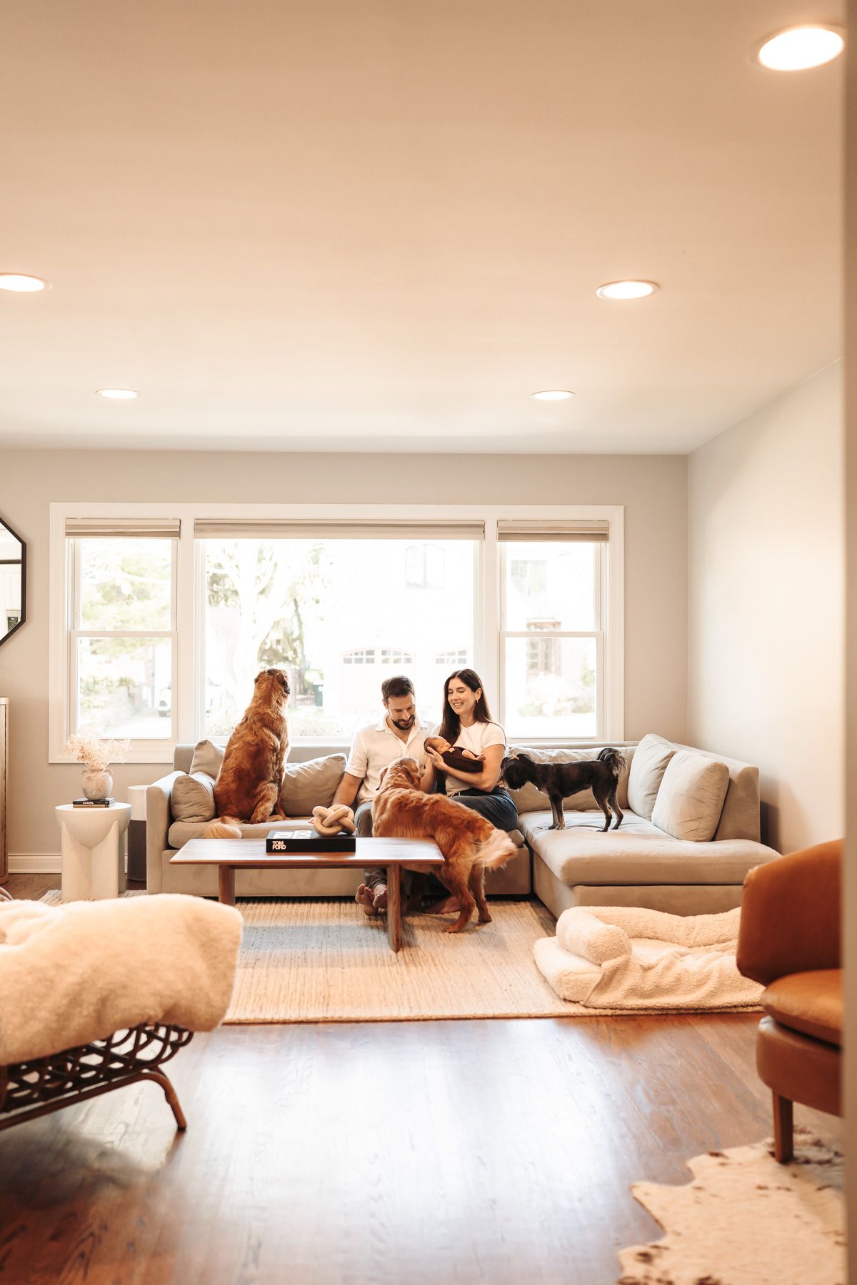 A photo showing people relaxing and lounging on cushions in a bright, minimalist room at lifestyle newborn session in Mount Prospect