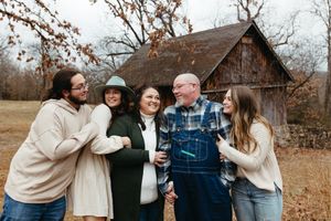 Family members share joyful moments together during an outdoor autumn photo session in casual attire.