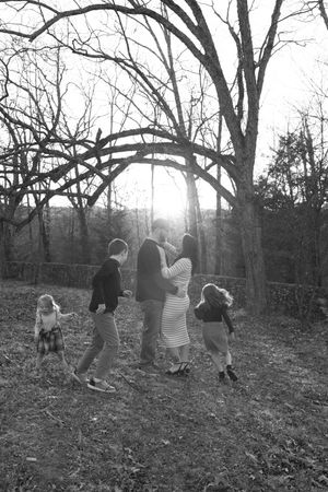 A sequence of black and white photos shows a group walking together through a wooded area on an autumn day.