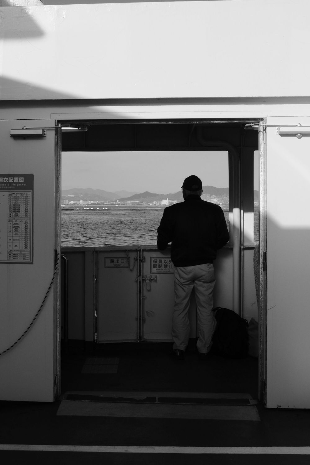 A sequence of black and white photos showing a person looking out of a window or opening at different angles.