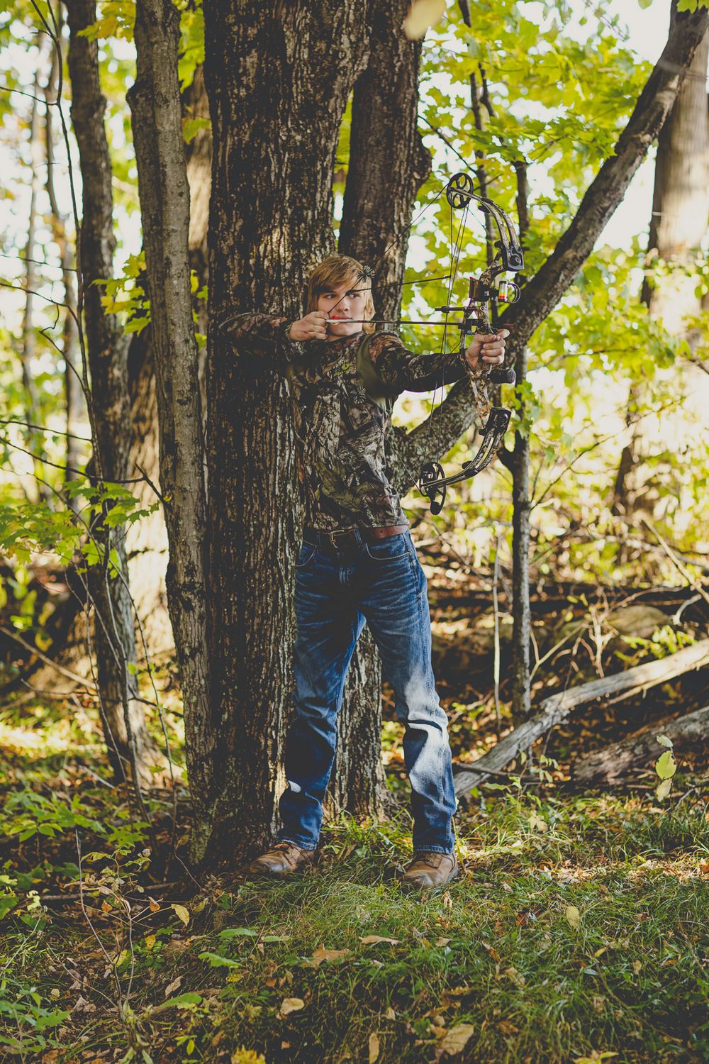 Person walking through a wooded area wearing jeans and boots on an autumn day.