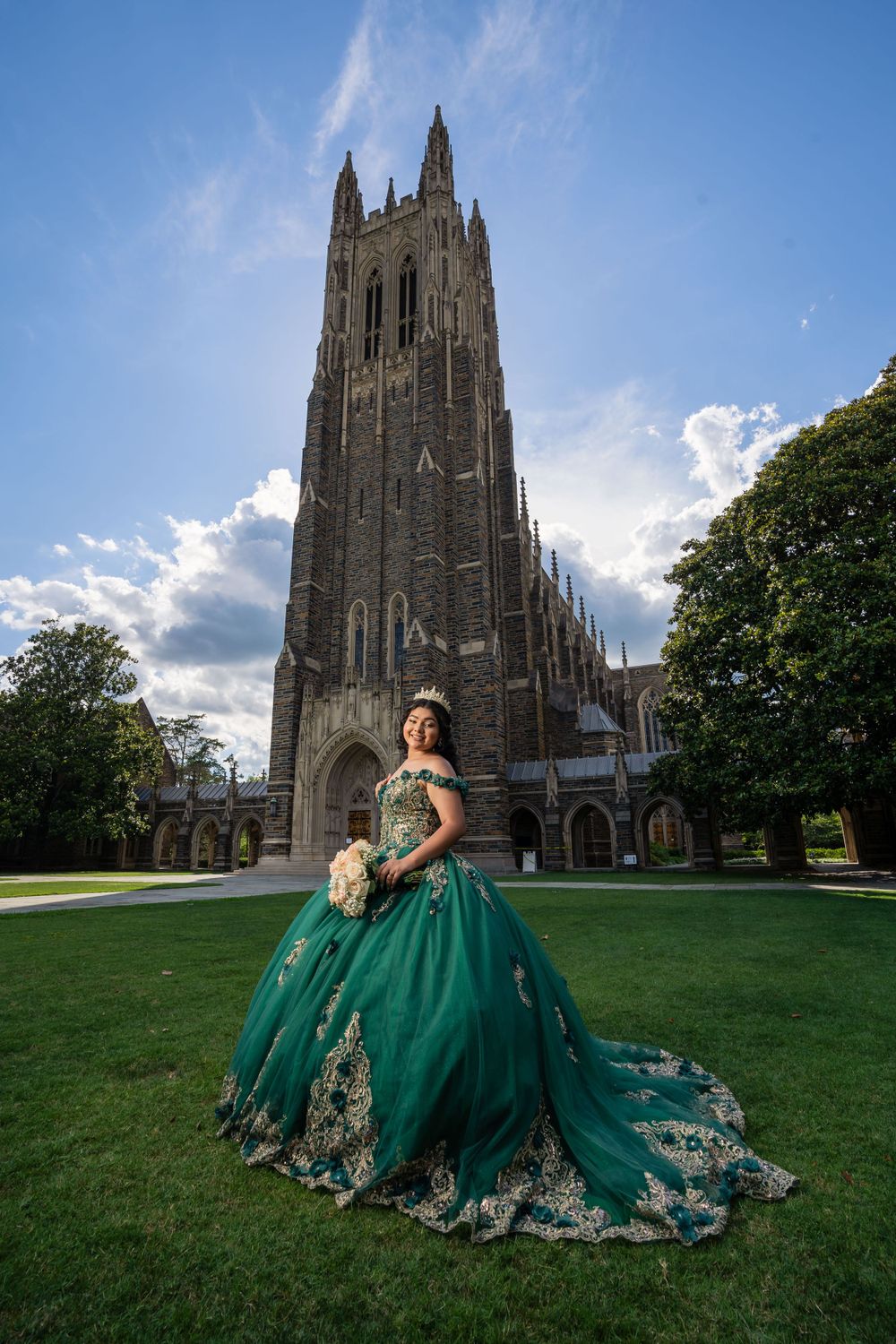 Stunning emerald green ballgown with gold embellishments photographed in front of Duke Chapel's Gothic architecture.
