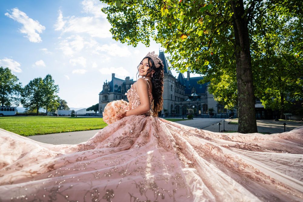 Blush pink princess gown with long train photographed on castle grounds.