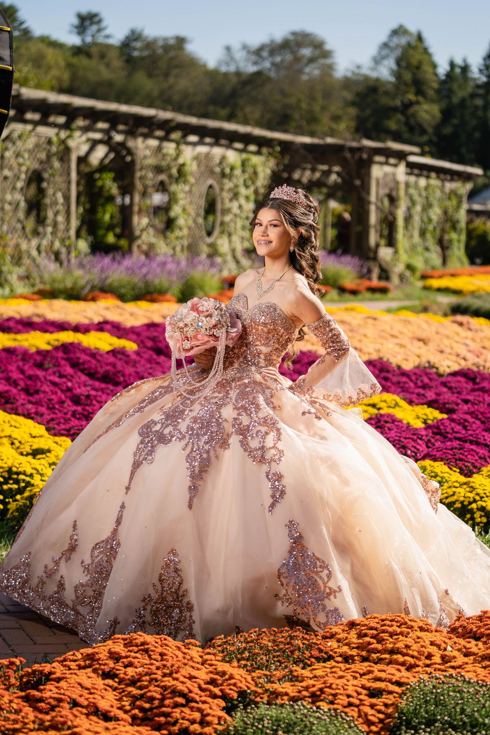 Champagne colored ball gown with floral appliques photographed in colorful flower garden.